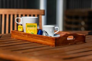 a wooden tray with two coffee cups on a table at Bonjardim Terrace in Porto