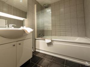 a bathroom with a tub and a sink and a bath tub at Hotel La Basilique in Épinal