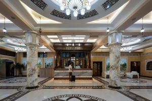 a lobby of a hotel with a person standing in the lobby at Kiropol Hotel & Restaurant in Dushanbe