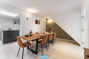 a dining room with a wooden table and chairs at Maison La Roussette - in the heart of Nieuwpoort in Nieuwpoort