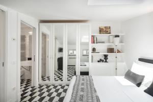 a white bedroom with a black and white checkered floor at The Roof Sorrento in Sorrento