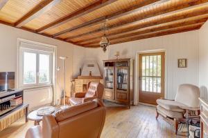 a living room with a couch and chairs and a table at Les Bois Noirs - appt vue montagne in Arconsat