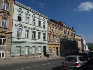 une voiture garée devant les bâtiments dans une rue dans l'établissement Apartment Brno Reissigova, à Brno