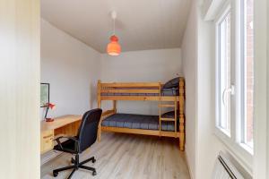 a small room with a desk and a bunk bed at Les Bois Noirs - appt vue montagne in Arconsat