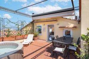a patio with a table and chairs and a hot tub at The Roof Sorrento in Sorrento +11 photos