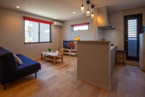 a kitchen and living room with a couch and a table at かなわアパートメントステイ202 in Tsuruga