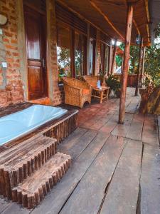 a porch with a hot tub on a house at Sipi Falls Lodge in Sipi
