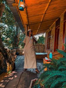 a man standing on the porch of a house at Sipi Falls Lodge in Sipi
