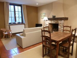 een woonkamer met een bank, een tafel en een open haard bij Maison Chantraine in Ramillies