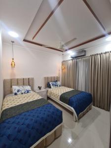 a bedroom with two beds and a window at Rivaj palace in Niāziān +7 photos