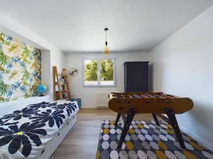 a bedroom with a bed and a table in it at Maison pour 8 avec jardin a 600m de la plage in Le Sablais