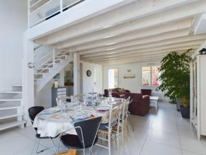 a white dining room with a table and chairs at Maison pour 8 avec jardin a 600m de la plage in Le Sablais