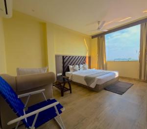 a bedroom with a bed and a chair and a window at Fun N City Water Park , Adventure & Resort , Patna in Nadwān +43 photos