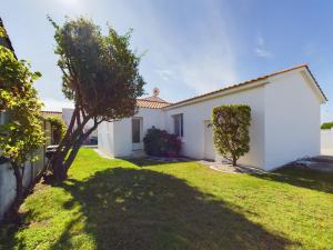 a white house with a green yard at Maison pour 8 avec jardin a 600m de la plage in Le Sablais