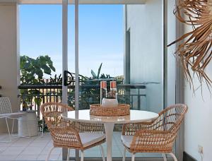 a white table and chairs on a balcony at 128 Santai - Stylish Resort Apartment by uHoliday in Casuarina