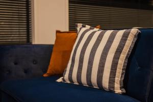 a blue couch with pillows on top of it at Fitzgerald Focus - Your 1BR Urban Oasis in Christchurch