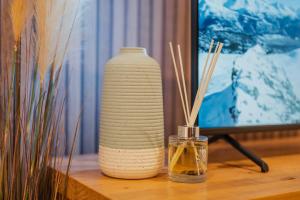 a white vase sitting on a table in front of a television at Cashel Grandeur - Luxurious 4-Bedroom Home in Christchurch