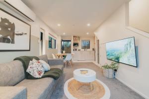 クライストチャーチにあるMisty Meadows Manor - Your Urban Oasisのソファとテーブルのあるリビングルーム