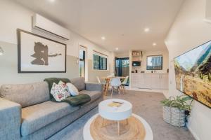 クライストチャーチにあるMisty Meadows Manor - Your Urban Oasisのソファとテーブルのあるリビングルーム