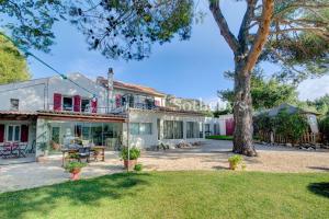an exterior view of a house with a tree at Domaine entier au havre de paix 4 chambres in Vauvenargues