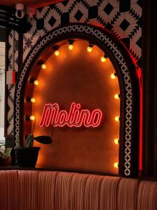 a neon sign that says muna on a wall at La Petite Salil Sukhumvit 11 in Bangkok