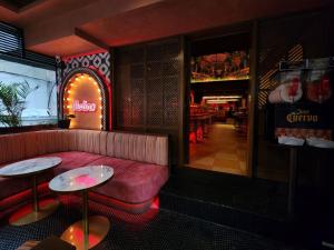 a restaurant with a red couch and tables in a room at La Petite Salil Sukhumvit 11 in Bangkok +46 photos