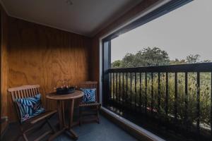 a balcony with a table and chairs and a large window at The Hagley Park Stunna in Christchurch