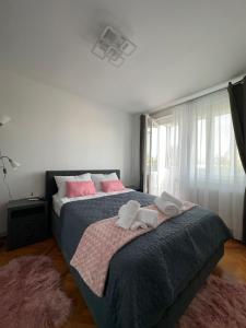 a bedroom with a large bed with pink pillows at Apartament Andrei in Turda