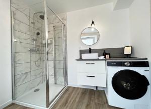 a bathroom with a shower and a washing machine at Le Meunier in Chouilly