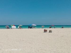 a group of people on a beach with umbrellas at Maison la rose 2 chambres in Mezraya