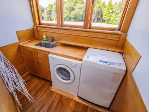 a kitchen with a washing machine and a sink at MJ's Retreat Stunning Ski Season Special for 2024 in Ohakune
