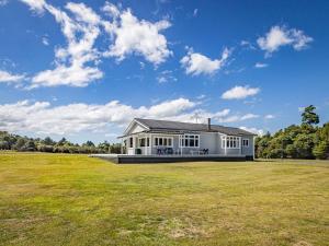 a large white house with a large grass field at MJ's Retreat Stunning Ski Season Special for 2024 in Ohakune