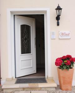 a white door on a house with a vase of flowers at Pension Weindl in Notzing