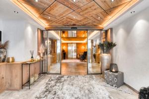 a hallway with a wooden ceiling and a living room at Hotel Sonne Ischgl in Ischgl