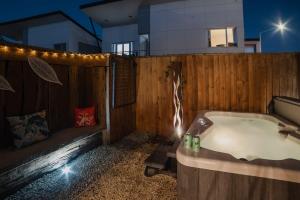 a bath tub with a wooden fence in front of a house at Central City Paradise in Christchurch +14 photos