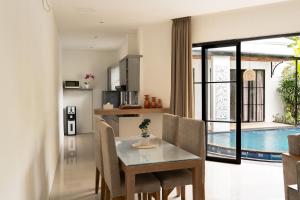 レギャンにあるAwila Villas Kutaのキッチン、ダイニングルーム(テーブル、プール付)