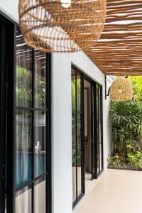 een gevel van een huis met een houten plafond bij Awila Villas Kuta by The Wina Resorts in Legian +39 foto's