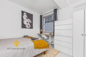 a white bedroom with a bed and a desk at Fantastic 4 bedroom apartment in Russell Square in London +7 photos