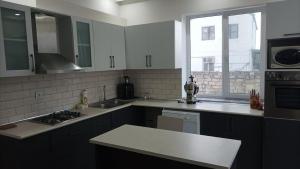 a kitchen with white cabinets and a stove top oven at House with pool near Sea Breeze in Baku