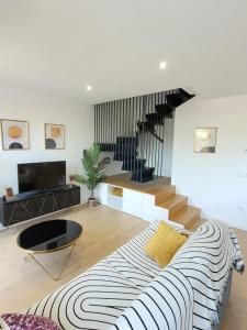 a living room with a couch and a staircase at Townhouse with jacuzzi, sauna, beach and barbeque in Villajoyosa