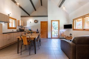 cocina y comedor con mesa y sofá en Chalet Arclosan - Val de Tamié, en Faverges