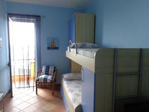 Un dormitorio con dos literas y una silla. en Casa con terrazzo e scala diretta sul mare, en Capo dʼOrlando 7 fotos más