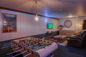 a living room with a large foosball table at The Dream Townhouse in Christchurch