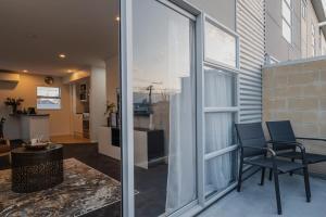 a living room with two chairs and a window at The Dream Townhouse in Christchurch
