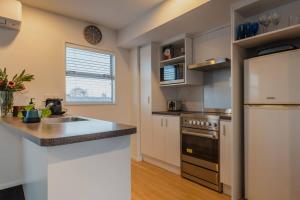 a kitchen with a sink and a refrigerator at The Dream Townhouse in Christchurch