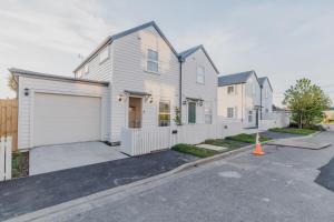 a white house with a white garage at Garden View 2-Bedroom Getaway in Christchurch in Christchurch