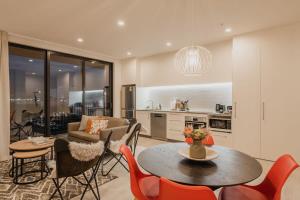 a kitchen and living room with a table and chairs at Tuam on Top Sleeps 5 in Christchurch