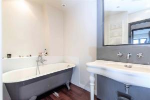 a bathroom with a bath tub and a sink at Gray D'Albion Cannes 2 BDR Apartment in Cannes +8 photos