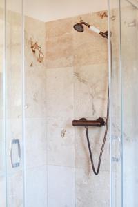 a shower with a shower head in a bathroom at Słoneczny Domek Rostki in Rostki