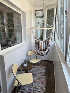 un portico con 2 sedie e un'amaca sul balcone di Chic Urban Retreat a Drîmbar